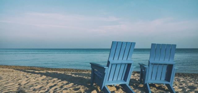 two blue chairs on the beach